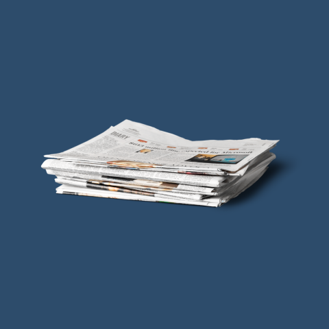 A stack of newspapers against a dark blue background.